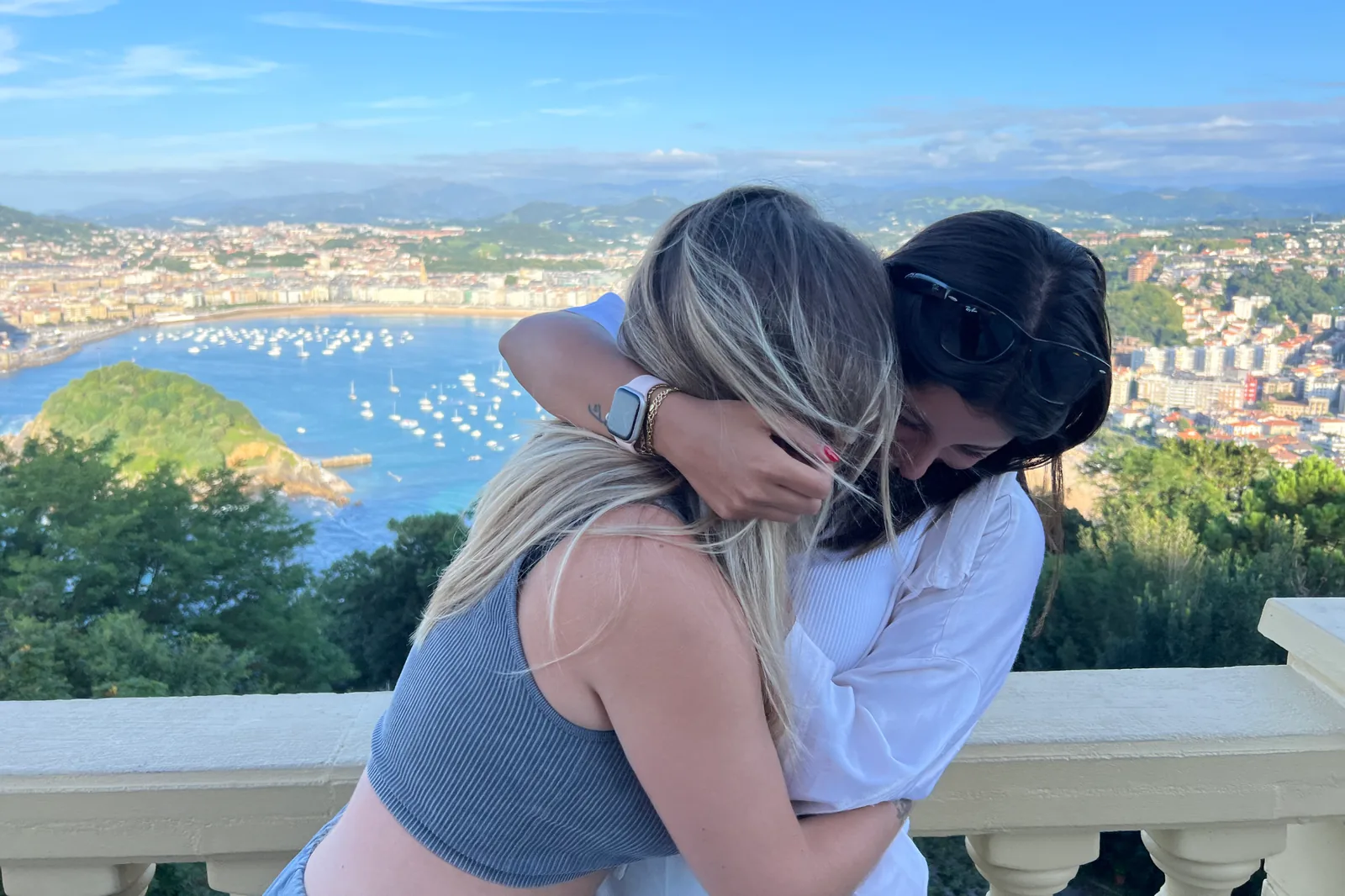 Dos personas abrazándose frente a un paisaje costero