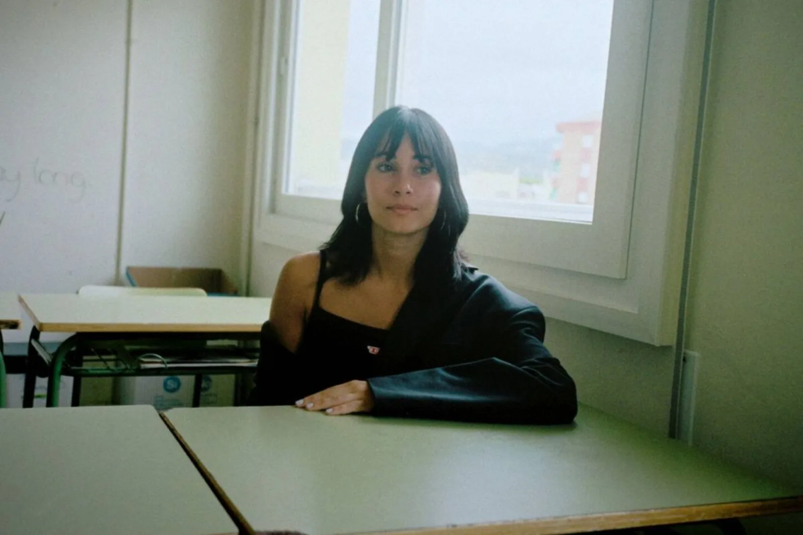 Aitana sentada en un aula frente a una ventana