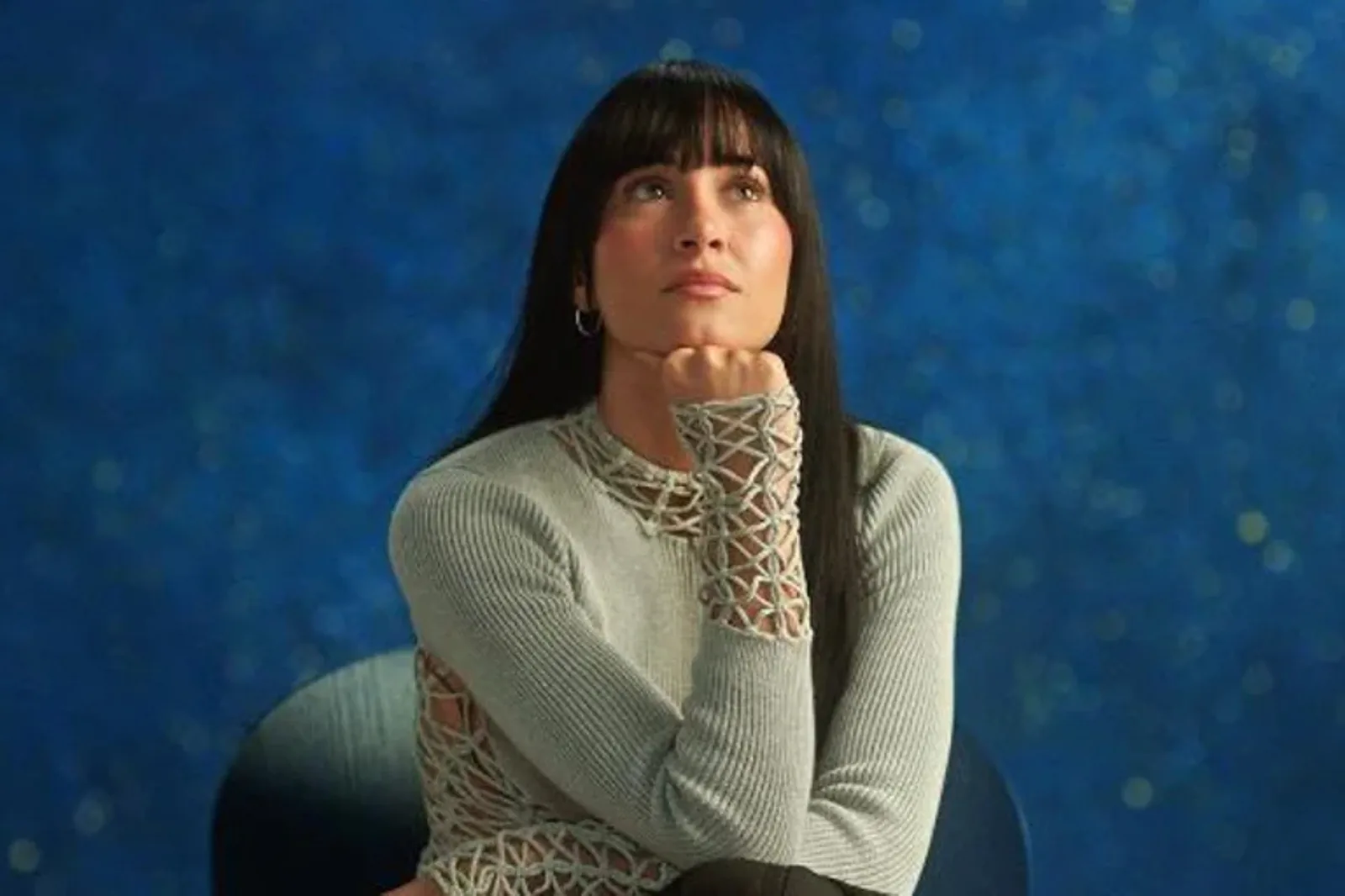 Aitana frente a un fondo azul