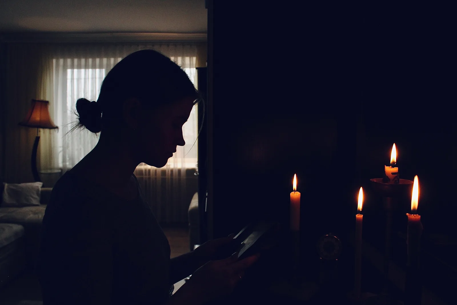 Mujer sentada en una habitación iluminada por velas