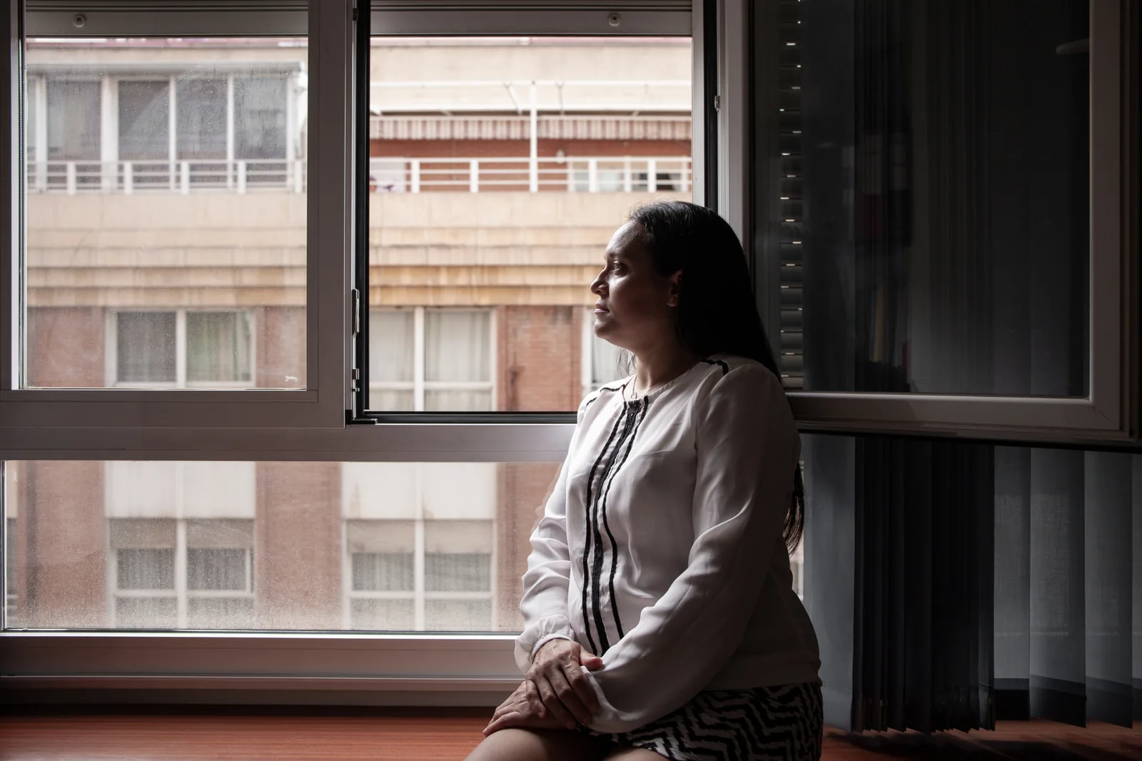 Mujer sentada junto a una ventana